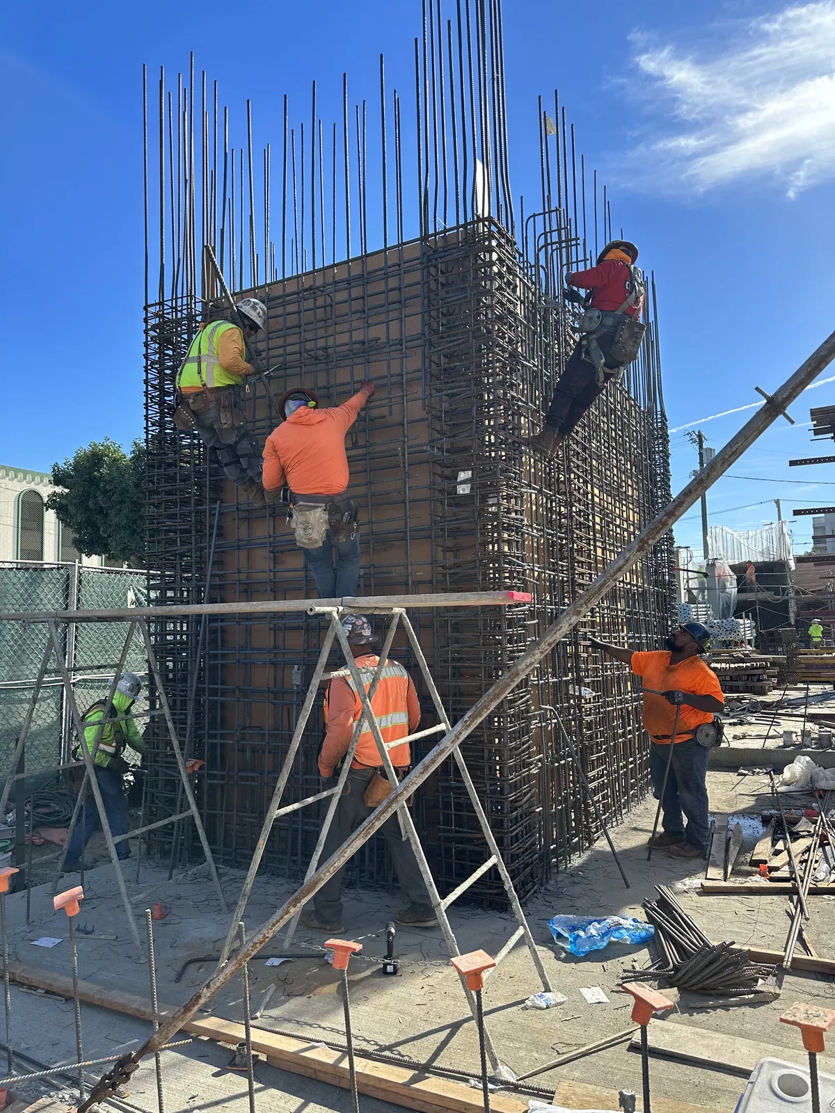 Crew tying a tall column rebar cage inside formwork — engineered reinforcement at work